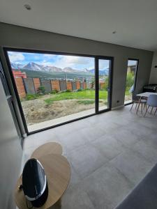 uma sala de estar com uma grande janela com vista em Andino House em Ushuaia