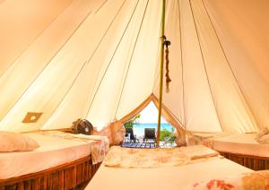 Cette tente comprend 2 lits et offre une vue sur l'océan. dans l'établissement Glamping EcoLodge Cueva De Las Aguilas, à Pedernales