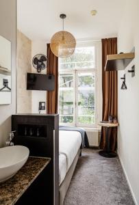 ein Schlafzimmer mit einem Bett, einem Waschbecken und einem Fenster in der Unterkunft Boutique Hotel View in Amsterdam