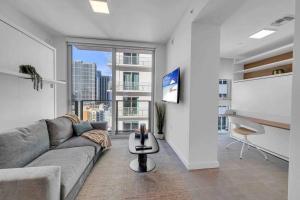 a living room with a couch and a large window at Breathtaking 1BR in the Heart Miami in Miami