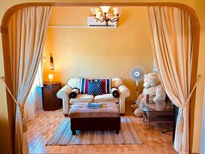 a living room with a couch and a teddy bear at RNM The Clubhouse, Grenada in Mount Nesbit