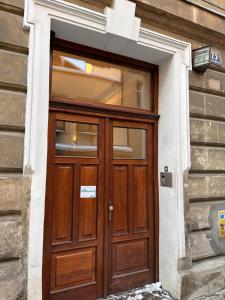 a wooden door on a building with a window at Centrum Apartamenty Stare Miasto in Kraków