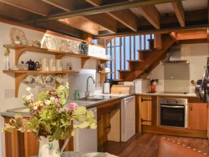 a kitchen with wooden cabinets and a sink with a vase of flowers at Chetnole Mill in Chetnole