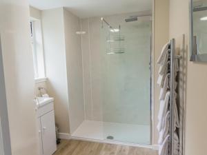 a shower with a glass door in a bathroom at Keepers Cottage - Uk30246 in Cray