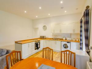 a kitchen with white cabinets and a table and chairs at Easter Caiplich - Uk30263 in Cray