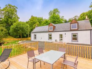 een huis met een terras met een tafel en stoelen bij Dalnaglar Cottage - Uk30260 in Cray