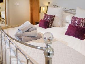 a bedroom with a bed with towels on it at Howgills Barn in Middleton