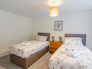 ein Schlafzimmer mit 2 Betten und eine Kommode mit einem Nachttisch in der Unterkunft Easter Caiplich - Uk30263 in Cray