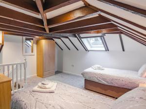 a attic bedroom with two beds and two windows at Wester Caiplich - Uk30261 in Cray
