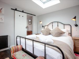 a bedroom with a bed with white sheets and pillows at Stargazing Retreat - Uk32423 in Merton