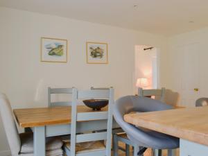 comedor con mesa de madera y sillas en Glenmeanich Cottage - Uk33789, en Bridgend