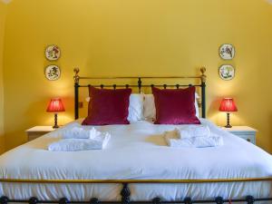a bedroom with a large white bed with red pillows at 1 The Reading Room Cottages - Uk37359 in Barningham