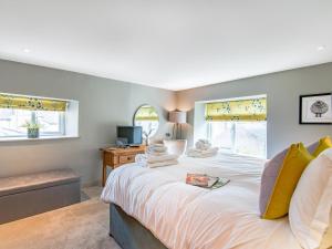 The Townhouse Richmond في ريتشموند: غرفة نوم بسرير ذو شراشف بيضاء ومخدات صفراء