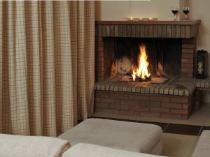 a brick fireplace with a fire in it at Karayiannis Villas in Nafplio