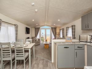 a kitchen and living room with a table and chairs at Burray in Mey