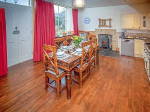 een keuken en eetkamer met een tafel en stoelen bij Purves Cottage in Allanton