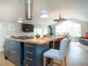 a kitchen with a blue island with a counter top at Meadowside in Saint Mawes