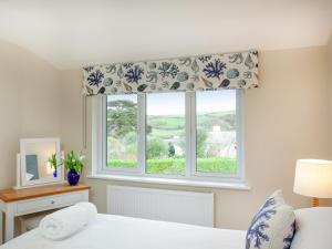 a bedroom with a window with a window shade at Meadowside in Saint Mawes