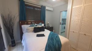 a bedroom with a large bed with blue curtains at Kozy Bahamas Getaway in Nassau