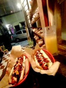 due hot dog in cestini su un tavolo con un bicchiere di succo d'arancia di Casa Tewa a San Luis Potosí