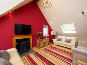 a living room with red walls and a fireplace at Skye Fall in Letterfinlay