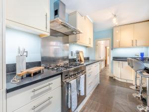 a kitchen with white cabinets and a stove top oven at The Shrubbery in Worcester