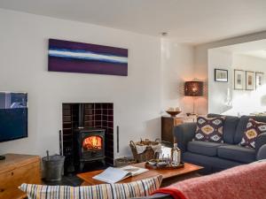 a living room with a couch and a fireplace at The Cottage in Leitholm