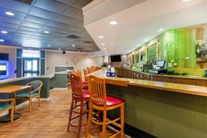 a bar in a restaurant with wooden chairs at The Lux Hotel & Conference Center, Ascend Hotel Collection in Waterloo