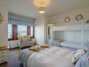 1 dormitorio grande con 2 camas y 1 silla en The Wee Nunnery - Uk7123, en Skelmorlie