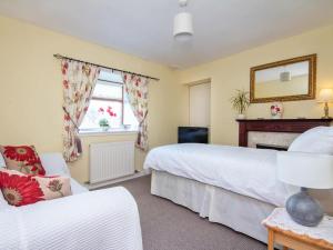 a bedroom with two beds and a fireplace at Black Rock Cottage in Culbokie