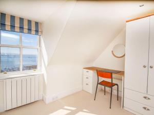 a white attic room with a desk and a window at Braefoot in Fortrose