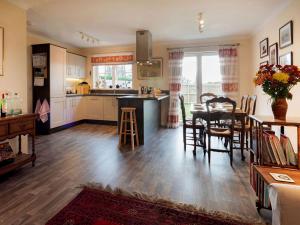a kitchen and living room with a table and chairs at Grant Crescent in Dornoch