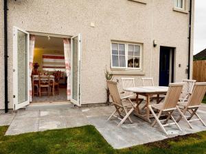 a patio with a table and chairs in front of a house at Grant Crescent in Dornoch