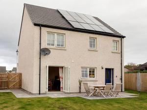 a house with a solar roof with a table and chairs at Grant Crescent in Dornoch