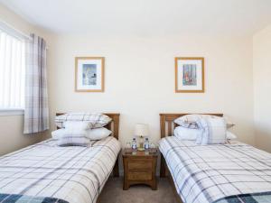 two twin beds in a room with a window at Raasay in Dornoch