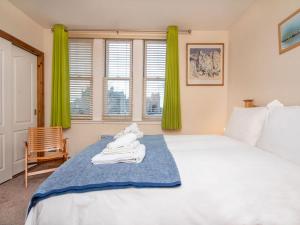 a bedroom with a large white bed with green curtains at Birds Eye View in Dornoch