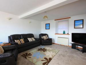 a living room with two couches and a flat screen tv at The Old Chandlery in Avoch