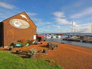 a building next to a body of water with boats at The Old Chandlery in Avoch