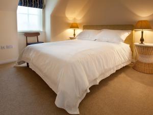 a large white bed in a bedroom with two lamps at Number 2 - Uk7451 in Dornoch