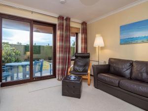 a living room with a leather couch and a table at Strathy in Dornoch