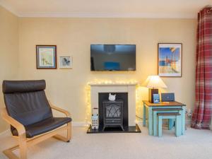 a living room with a chair and a fireplace at Strathy in Dornoch