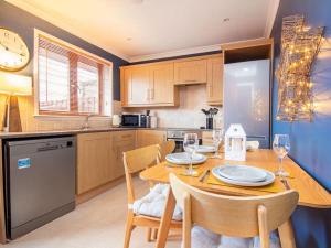 a kitchen with a wooden table with chairs and a dining room at Strathy in Dornoch