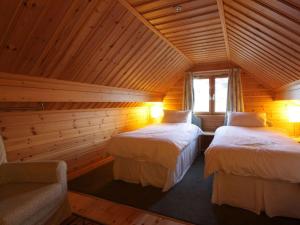 a room with two beds in a log cabin at Taigh Fiodha in Balintore