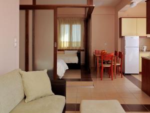 ナフプリオにあるKarayiannis Villasのリビングルーム(ソファ、テーブル付)、キッチンが備わります。