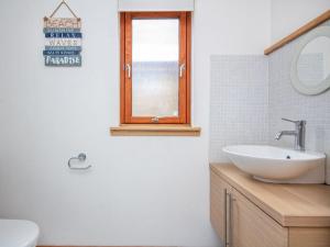 a white bathroom with a sink and a mirror at The Hive in Dornoch