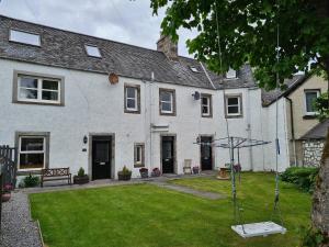 a house with a yard with a swing at The Old Library in Brora