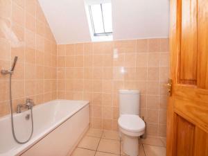 a bathroom with a toilet and a bath tub at Fernabeg in Edderton