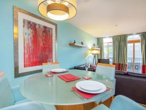 a dining room with a glass table and chairs at 208 By The Bridge Apartment in Inverness