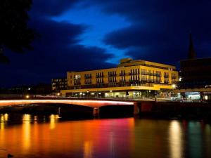 a bridge over a river in front of a building at 208 By The Bridge Apartment in Inverness