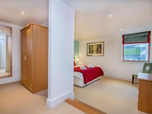 a bedroom with a red bed and a window at 208 By The Bridge Apartment in Inverness